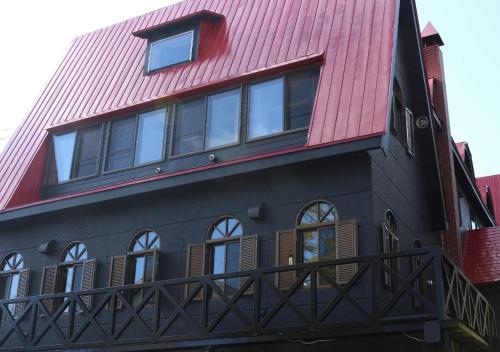 a black and red house with a red roof at Pension Fullnote in Kutchan
