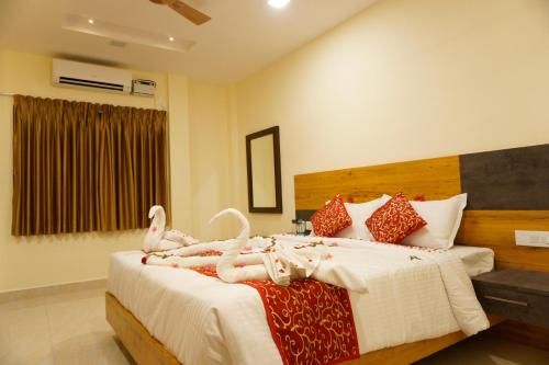 um quarto com uma cama com cisnes em THE CHIRAAG INN em Chennai