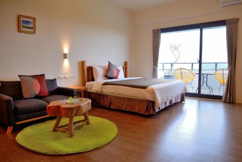 a bedroom with a bed and a couch and a table at 有棵樹特色民宿The Tree in Hengchun