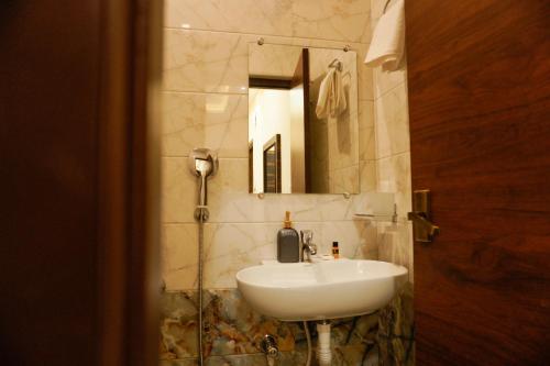 bagno con lavandino e specchio di THE CHIRAAG INN a Chennai