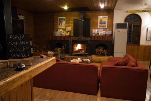 a bar with two red chairs and a fireplace at Pension Fullnote in Kutchan