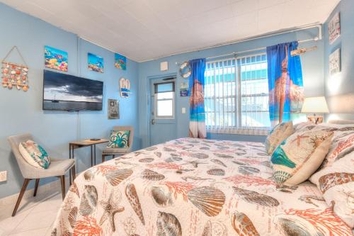 a bedroom with a large bed with blue walls at Tropic Terrace #11 - Beachfront Rental condo in St. Pete Beach