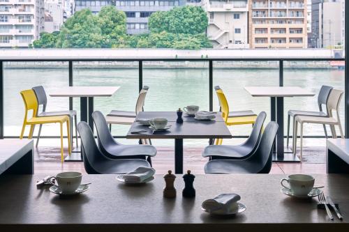 una mesa y sillas con vistas al agua en The Gate Hotel Ryogoku by Hulic, en Tokio