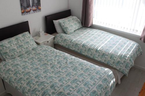 1 dormitorio con 2 camas y ventana en Potters House Coventry warwickshire en Coventry