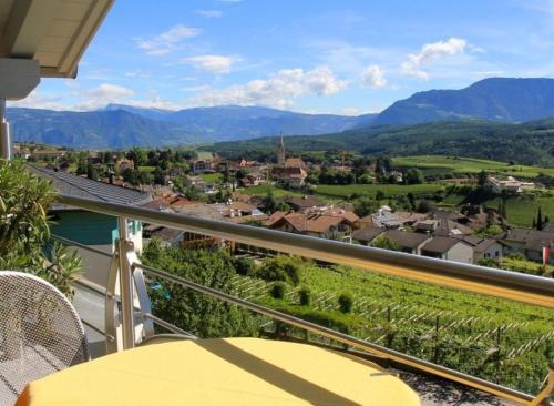a balcony with a view of a town and mountains at Millenniumshof in Caldaro