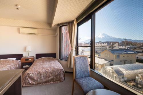 una camera d'albergo con due letti e una grande finestra di Shiki-no-Yado Fujisan a Fujikawaguchiko