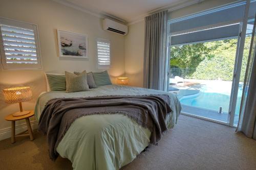a bedroom with a bed and a large window at The Shack Noosa in Noosa Heads