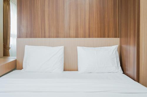 a bed with white sheets and pillows in a room at Fully Furnished with Comfortable Design 2BR Apartment Atria Residences By Travelio in Tangerang