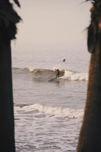 a man riding a wave on a surfboard in the ocean at The Mantra Hotel Kata Noi in Kata Beach