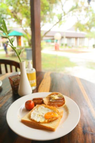 un piatto di cibo con uova e pane su un tavolo di Rungan Sari Meeting Center & Resort a Guhung