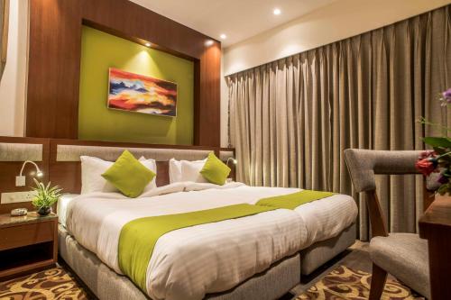a bedroom with a large bed with a green wall at Club Central in Bolpur