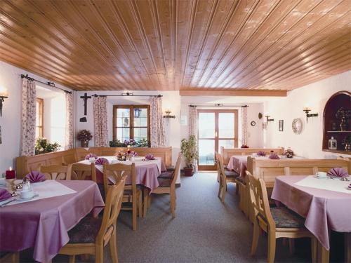 uma sala de jantar com mesas e cadeiras com toalha de mesa roxa em Gästehaus Hubertushof em Bad Feilnbach