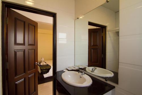 a bathroom with a sink and a mirror at Hotel Yankin in Yangon