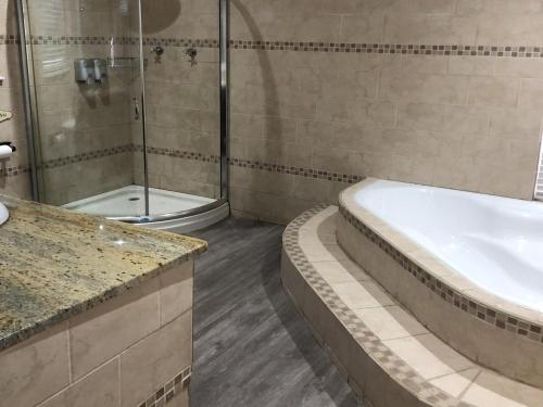 ein Badezimmer mit Dusche, Badewanne und Waschbecken in der Unterkunft The Homestead in Bloemfontein