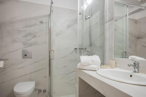 a bathroom with a toilet and a sink and a shower at Panorama Apartments Fiscardo in Fiskardho