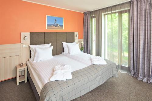 a bedroom with two beds and a large window at Wellton Riga Hotel & SPA in Rīga