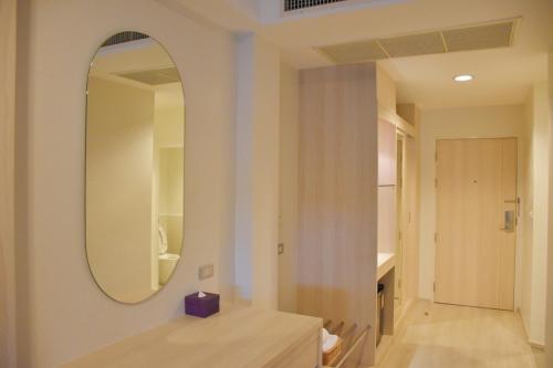 ein Badezimmer mit einem Spiegel und einem Holztisch in der Unterkunft Bangsaen Heritage Hotel - SHA Plus Certified in Bangsaen