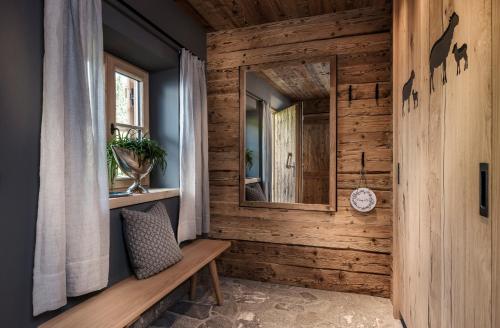 レオガングにあるBergWärtsGeist SENHOOG Luxury Holiday Homesの木製の壁の客室で、ベンチと鏡が備わります。
