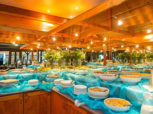 una línea de buffet con tazones y platos de comida en Knysna Log-Inn Hotel en Knysna
