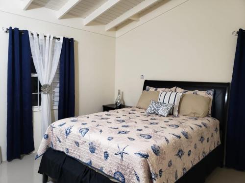 a bedroom with a large bed with blue curtains at Sehfeh Luxury vacation home in Falmouth