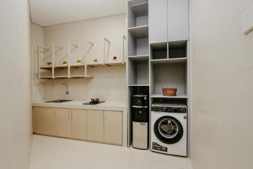 a kitchen with a washer and dryer in a room at House of Asiyah Syariah in Solo