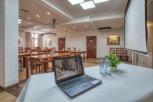 a laptop computer sitting on a table in a restaurant at Dom Oliwski in Gdańsk