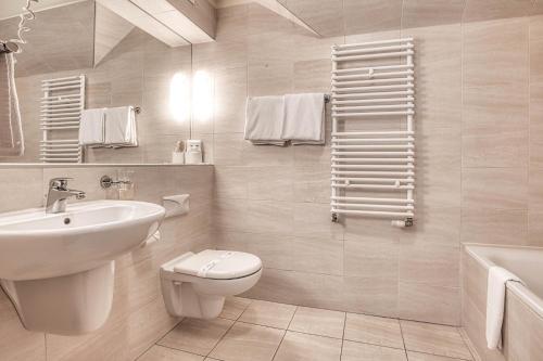 Dom Oliwski في غدانسك: حمام أبيض مع حوض ومرحاض