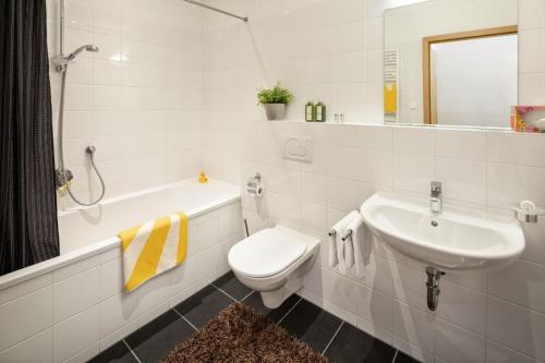 a white bathroom with a sink and a toilet at Fewo-Obertauern-Steinadler in Obertauern