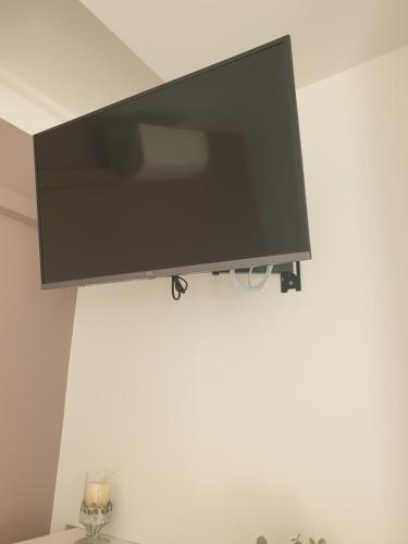 a flat screen tv hanging on a white wall at Mistral Appartements in Saint-Louis-du-Rhône