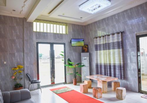 sala de estar con mesa y TV en White Horse Hotel Cotonou en Agblangandan