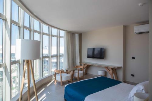 a hotel room with a bed and a desk and window at Redcon Suites in Hurghada