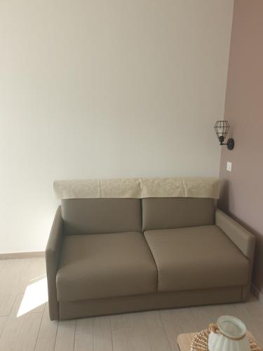 a couch in a room with a white wall at Mistral Appartements in Saint-Louis-du-Rhône