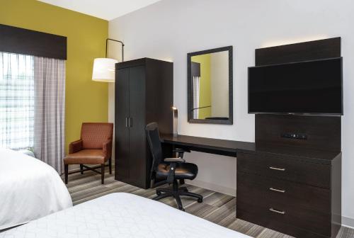 a hotel room with a desk and a television at Holiday Inn Express & Suites Florence by IHG in Florence