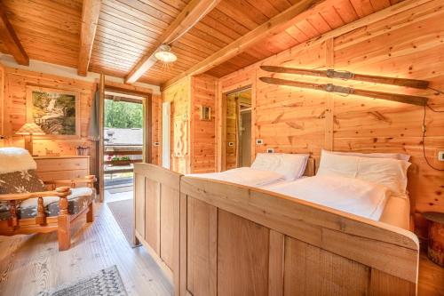 a bedroom with a bed in a log cabin at Baita Mas Sora Sass in Rabbi