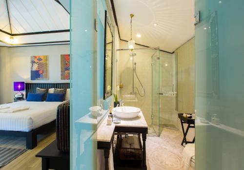 a bathroom with a bed and a sink and a shower at Moracea by Khao Lak Resort in Khao Lak