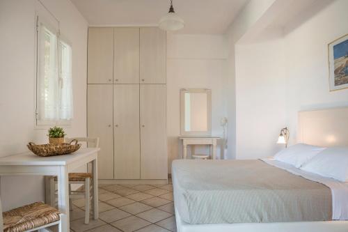 a bedroom with a bed and a table and a desk at Panorama Apartments Fiscardo in Fiskardho