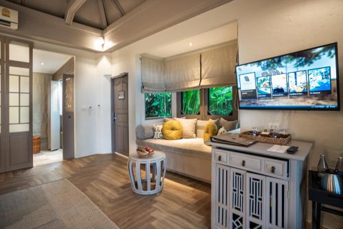 a living room with a couch and a large tv at Moracea by Khao Lak Resort in Khao Lak
