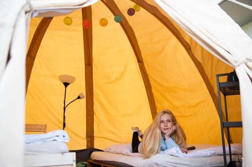 a girl sitting on a bed in a tent with a cat at Kemp Děčín in Děčín