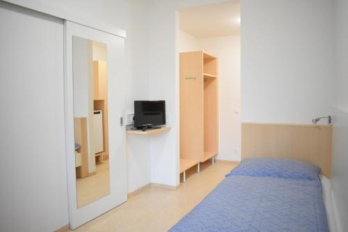małą sypialnię z łóżkiem i telewizorem w obiekcie SOVEA Hotel - City w Linzu