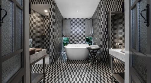 a bathroom with a large tub and a sink at Moracea by Khao Lak Resort in Khao Lak