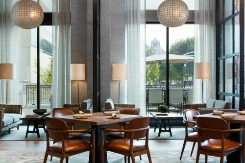 a restaurant with tables and chairs and large windows at Kimpton Hotel Arras by IHG in Asheville