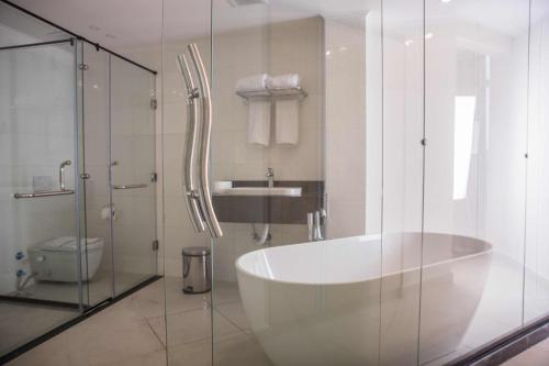 a bathroom with a large tub and a sink at Redcon Suites in Hurghada
