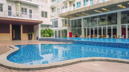 une grande piscine au milieu d'un bâtiment dans l'établissement Minimalist Studio at 11st Floor Bogor Icon Apartment By Travelio, à Kedunghalang