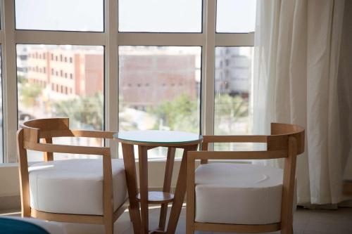 two chairs and a table in front of a window at Redcon Suites in Hurghada