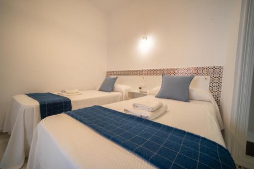 two beds with blue pillows in a room at BOHEMIA SANLUCAR in Sanlúcar de Barrameda