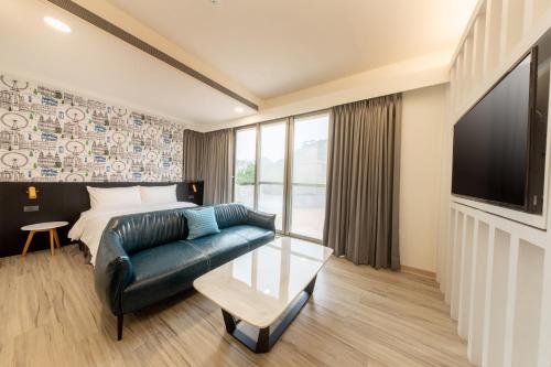 a living room with a couch and a flat screen tv at Only Love Motel in Xindian