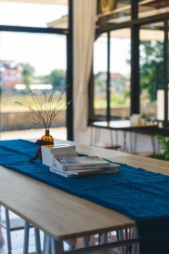 ein Tisch mit einer blauen Tischdecke und einem Buch in der Unterkunft Yindee Home & Cafe in Nan