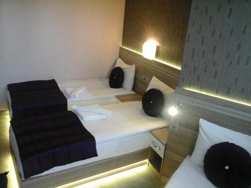 a small room with two beds and a couch at Olimpiyat Hotel Izmir in Izmir