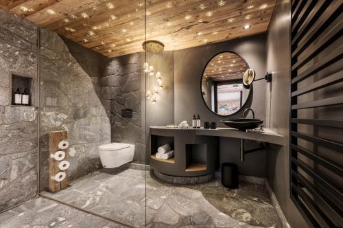 a bathroom with a sink and a mirror at GipfelKreuzLiebe Senhoog Luxury Holiday Homes in Leogang