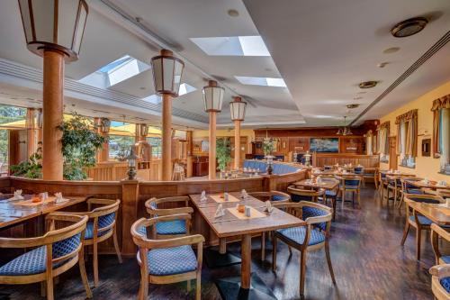 ein Restaurant mit Holztischen und blauen Stühlen in der Unterkunft Familien Wellness Hotel Seeklause mit großem Abenteuerspielplatz "Piraten-Insel-Usedom" Kinder immer All-Inklusive & Getränke ganztags inklusive in Trassenheide